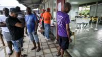 Des électeurs attendent pour voter lors des élections législatives, le 25 mai 2025 à Paramaribo, au Suriname