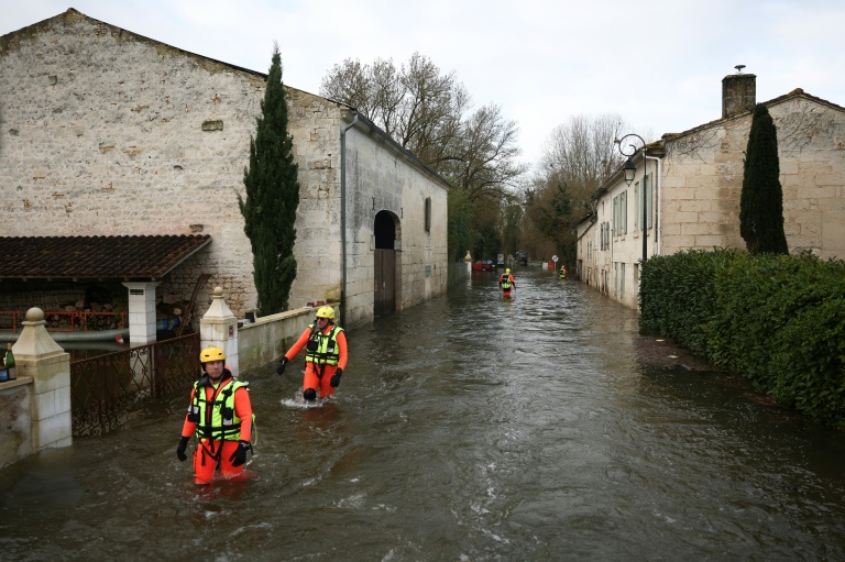 Des sauveteurs en mer dans une rue inondée lors d'une opération visant à évacuer des habitants isolés à Courcoury, en Charente-Maritime, le 21 février 2026