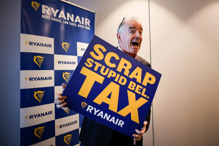 Michael O'Leary, PDG de la compagnie aérienne Ryanair pose avec une pancarte reprochant à la Belgique une série de taxes 
