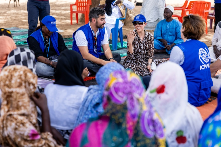 La directrice générale adjointe de l'Organisation internationale pour les migrations (OIM), SungAh Lee (d), s'entretient avec des Tchadiens de retour au pays à Adré, le 8 juin 2026 au Tchad