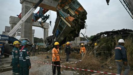Des secouristes sur le site du déraillement d'un train provoqué par l'effondrement d'une grue de chantier dans la province de Nakhon Ratchasima, en Thaïlande, le 14 janvier 2026