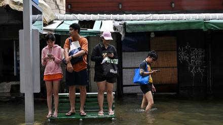 Des habitants sur un banc dans une rue de Bangkok, où l'état de catastrophe naturelle a été déclaré après des pluies diluviennes qui ont inondé habitations, commerces et axes de circulation, le 27 septembre 2026