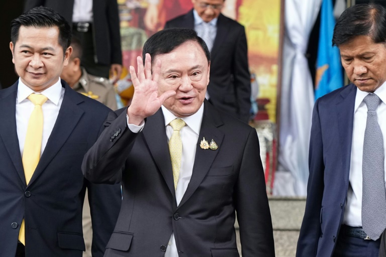 L'ancien Premier ministre thaïlandais Thaksin Shinawatra (c) quitte le tribunal après son acquittement à l'issue de son procès pour crime de lèse-majesté, le 22 août 2025 à Bangkok