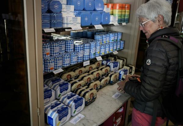 Une cliente regarde les boîtes de pastilles à la menthe Vichy produits par la confiserie Maison Moinet dans une boutique à Vichy, le 13 mai 2025 dans l'Allier