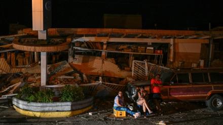 Des habitants sont assis devant des immeubles effondrés après un séisme historique Catia La Mar, le 25 juin 2026. 