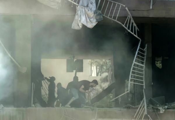 Des habitants recherchent des survivants sur le site d'une frappe aérienne israélienne qui a ciblé un bâtiment dans la banlieue sud de Beyrouth, le 14 juin 2026 au Liban