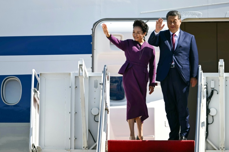 Le président chinois Xi Jinping et son épouse Peng Liyuan saluent de la main avant d'embarquer à bord d'un avion d'Air China au départ de la base Andrews, dans le Maryland, le 25 septembre 2026