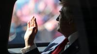 Le président américain Donald Trump effectue un salut de la main à bord de sa voiture, le 26 octobre 2025 à l'aéroport de Sepang en Malaisie
