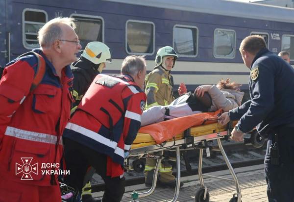 Photo diffusée par le Service ukrainien des situations d'urgence le 29 octobre 2026 montrant des secouristes ukrainiens transportant sur une civière une personne blessée après une attaque aérienne contre la gare de Dnipro, en Ukraine