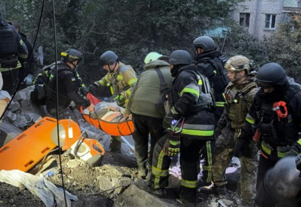 Des secouristes évacuent une personne blessée après une frappe russe sur un immeuble résidentiel de Zaporijjia dans le sud-est de l'Ukraine, le 10 octobre 2026