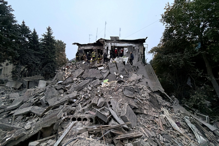 Des secouristes ukrainiens travaillent dans les décombres d'un immeuble de Zaporijjia, dans le sud-est de l'Ukraine, touché par une frappe russe le 10 octobre 2026