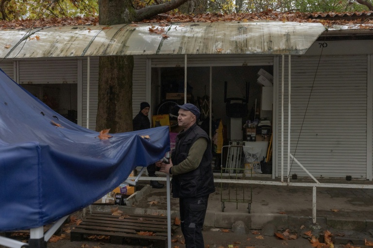 Kostiantyn, un vendeur de nourriture pour animaux,  s'apprêtent à fermer son étal, le 30 octobre 2026 à Kherson, dans le sud de l'Ukraine 
