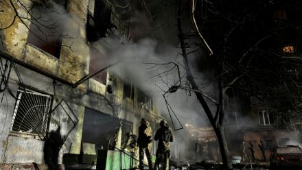 Des membres des forces de l'ordre sont mobilisés dans la cour d'un immeuble résidentiel endommagé à la suite d'une attaque aérienne russe à Zaporijjia le 25 novembre 2025 dans le sud de l'Ukraine