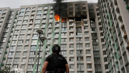Photo prise et publiée par les services de secours ukrainiens le 1er septembre 2026, montrant un policier devant un immeuble d'habitation en feu à Kiev, après une frappe russe