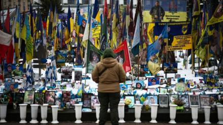 Une personne se tient devant un mémorial de fortune dédié aux soldats ukrainiens et étrangers tombés au combat, sur la place de l’Indépendance à Kiev, le 23 février 2026