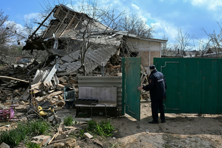 Un policier russe inspecte une maison détruite après une attaque aérienne à Yasynuvata, dans la région ukrainienne de Donetsk contrôlée par la Russie, le 11 avril 2026