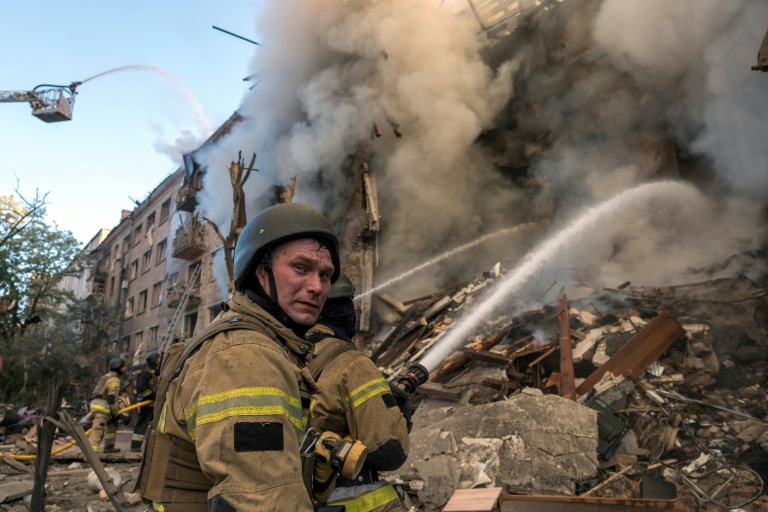 Des pompiers luttent contre un incendie après d'intenses bombardements russes nocturnes qui ont particulièrement visé la capitale ukrainienne, le 24 mai 2026 à Kiev