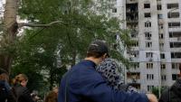Des habitants observent un immeuble résidentiel endommagé après une frappe de drone russe à Kiev, le 25 septembre 2026