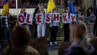 Des membres de la diaspora ukrainienne tiennent des pancartes formant le nom Oleshky (Olechky) devant l'ambassade américaine à Varsovie, le 6 octobre 2026, en Pologne
