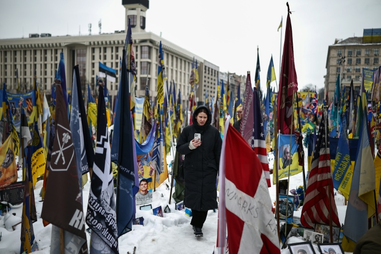 Une femme traverse un mémorial dédié aux soldats ukrainiens et étrangers tombés au combat, place de l'Indépendance à Kiev, le 23 février 2026, alors que le conflit avec la Russie entre dans sa cinquième année