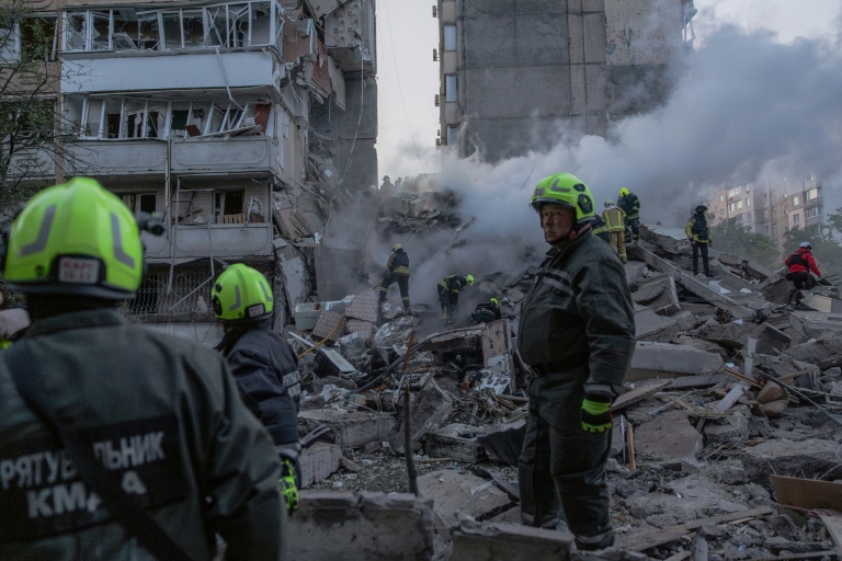 Les secouristes dans les ruines d'un immeuble détruit par une frappe russe à Kiev, le 14 mai 2026