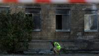 Un policier ukrainien inspecte des débris près d'un bâtiment endommagé par une frappe de drone russe à Kiev, le 1er octobre 2026