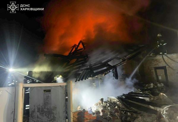 Photographie publiée par les services de secours ukrainiens montrant des pompiers luttant contre un incendie après une frappe de drone russe qui a tué un père et ses trois enfants dans une maison à Bogodoukhiv le 11 février 2026