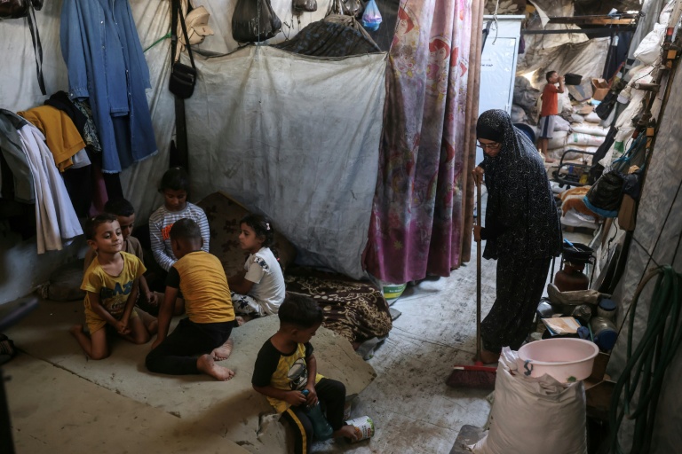 Nihaya Al-Masri (D), une Palestinienne déplacée qui vit avec ses huit enfants sous une tente à Khan Younès, dans le sud du territoire palestinien, le 6 octobre 2026 
