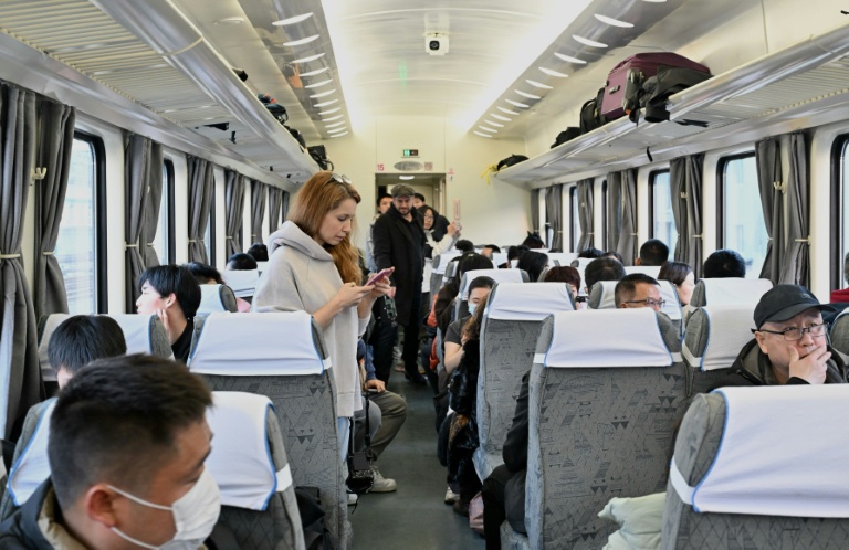 Des passagers à bord du train K27 à destination de Pyongyang à la gare de Pékin, le 12 mars 2026 en Chine