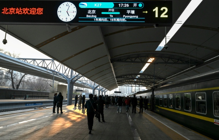 Des voyageurs montent à bord du train K27 à destination de Pyongyang, à la gare de Pékin, le 12 mars 2026 en Chine