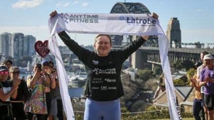 L'ex-footballeuse britannique Fran Hurndall entourée de supporteurs après avoir bouclé une course de charité de 3.800 kilomètres à travers l'Australie, le 29 juin 2025 à Sydney