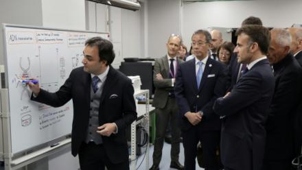 Nicolas Clément (g), directeur du LIMMS, en partenariat avec le Laboratoire international de recherche français CNRS, montre un graphique au président français Emmanuel Macron (à droite) lors de sa visite au laboratoire de Tokyo, le 1er avril 2026