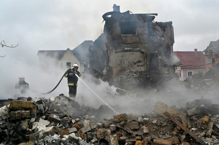 Des pompiers interviennent sur un incendie dans des maisons endommagées par une frappe russe dans la région de Kiev, le 25 mai 2025 en Ukraine