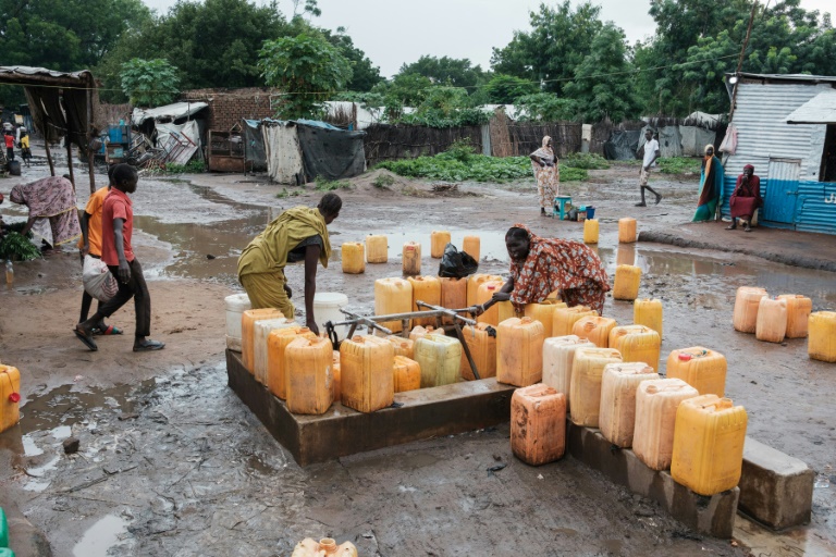 Des femmes remplissent des bidons d'eau à une pompe à Maban, le 20 août 2025 au Soudan du Sud