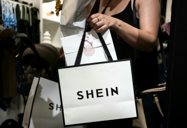 Une cliente porte des sacs après avoir fait des achats dans une boutique éphémère de la marque asiatique Shein, le 26 juin 2025 à Diajon, en Côte-d'Or