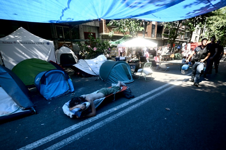 Des personnes récemment expulsées d'un centre social à Rome campent à l'extérieur du centre, le 11 août 2026