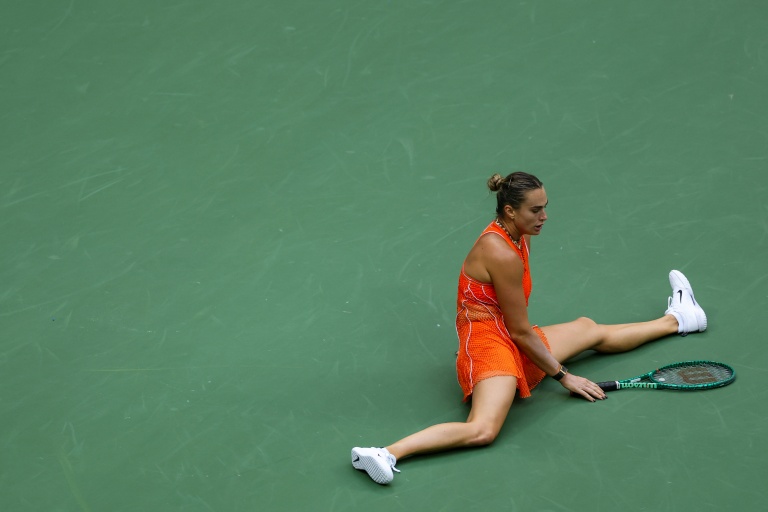 La Bélarusse Aryna Sabalenka s'effondre sur le court face à la Kazakhstanaise Elena Rybakina (hors-champ) lors de la finale de l'US Open, à New York, le 12 septembre 2026