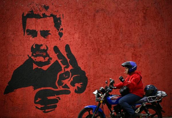 Un homme passe près d'une fresque représentant Nicolas Maduro, le 14 mai 2026 à Caracas