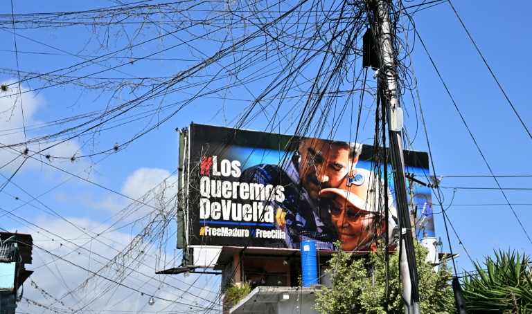 Un panneau d'affichage montrant une photo de l'ancien président vénézuélien Nicolas Maduro et de son épouse, Cilia Flores, dans le quartier de Petare à Caracas, le 14 mai 2026