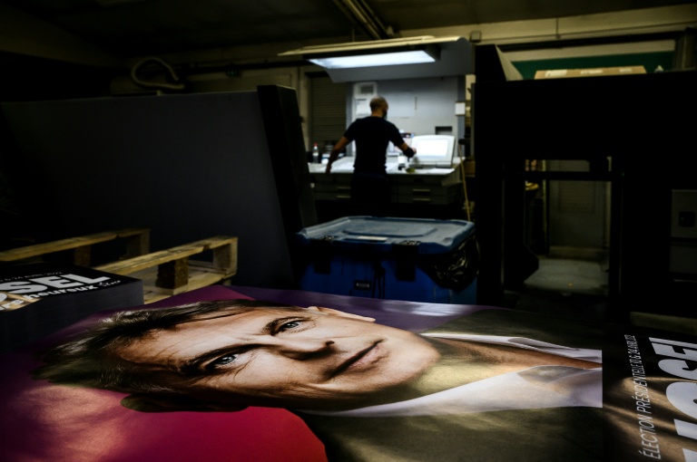 Un employé vérifie un poster de campagne électorale de Fabien Roussel, alors candidat du PCF à l'élection présidentielle, le 21 janvier 2022 à Vénissieux, dans le Rhône