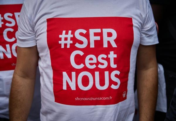 Salariés de SFR manifestant devant le siège de la maison-mère Altice, à Paris le 24 septembre 2026, à l'appel des syndicats UNSA, CFDT et CFTC pour protester contre la vente de la société.