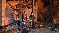Des secouristes ukrainiens sur le site d'une frappe de drone sur une infrastructure énergétique à Kharkiv, le 7 octobre 2025