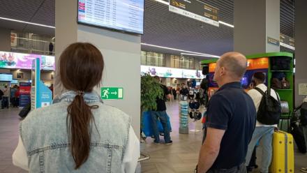 Des passagers regardent un panneau d'affichage des vols à l'aéroport de Kaliningrad, en Russie, le 4 juillet 2026
