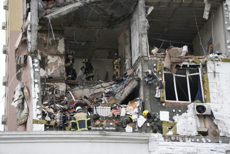 Des secouristes ukrainiens fouillent un bâtiment touché par une attaque de missiles et de drones russes, le 27 décembre 2025 à Kiev 